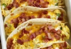 Delicious baked breakfast tacos with eggs, cheese, and toppings