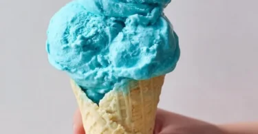 A scoop of Blue Moon Ice Cream in a vibrant blue color in a waffle cone
