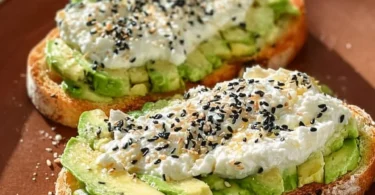 Delicious avocado toast topped with cottage cheese and fresh herbs