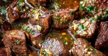 Delicious Cowboy Butter Steak Bites served with herbs and seasoning