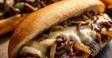 Delicious slow cooker Philly Cheesesteak served with melted cheese and peppers.