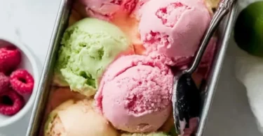Bowl of colorful homemade rainbow sherbet with scoops of vibrant flavors.