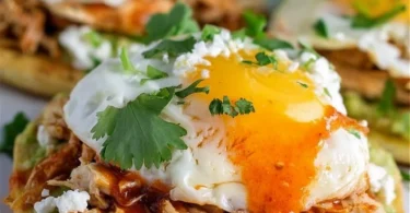 Mexican Eggs Benedict topped with avocado and salsa on a plate