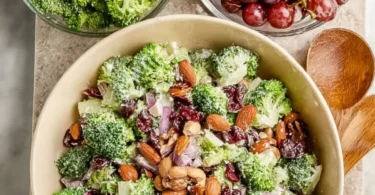 Colorful vegan broccoli salad with nuts and dressing in a bowl