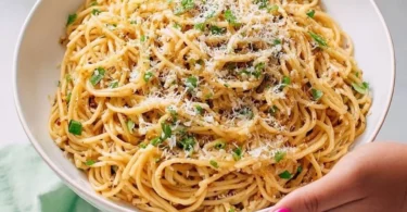 Delicious Vietnamese Garlic Noodles garnished with herbs and vegetables