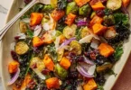 Warm roasted veggie salad with maple Dijon vinaigrette in a bowl